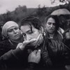 6/11/1998, Izbica, Kosovo, Yugoslavia. Dayna Smith, USA, The Washington Post. A woman is comforted by relatives and friends at the funeral of her husband. The man was a soldier with the ethnic Albanian rebels of the Kosovo Liberation Army, fighting for independence from Serbia. He had been shot the previous day while on patrol.
