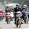 Hình (NPR): Một người vừa chạy xe gắn máy vừa dùng điện thoại di động tại Hà Nội.