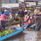 Hình (Allan Rickmann): Một người dùng điện thoại di động để liên lạc trong việc mua bán tại chợ nổi, miền Tây, Đồng Bằng Sông Cửu Long.