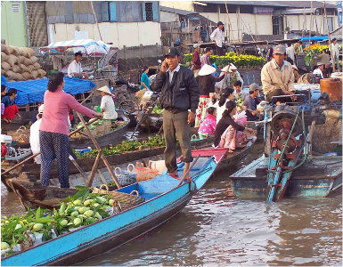 Hình (Allan Rickmann): Một người dùng điện thoại di động để liên lạc trong việc mua bán tại chợ nổi, miền Tây, Đồng Bằng Sông Cửu Long.