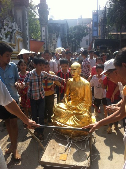 Pho tượng đồng được trụ trì Thích Minh Phượng tự ý đúc, để thay thế bức tượng phật cổ trong chùa Chân Long, bị người dân trong xã Chàng Sơn kéo ra giữa chợ.