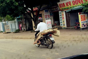 Do không có tiền thuê xe ô tô nên gia đình chị P đã nhờ người quen sử dụng xe máy chở thi thể về mai táng. Ảnh & chú thích: Dân Việt